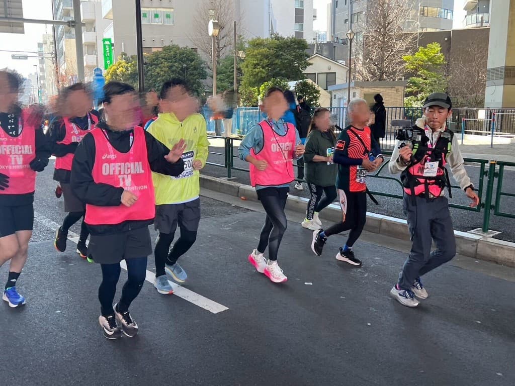 東京マラソンのコースでジンバル装備のカメラマンがランナーと並走して撮影している様子